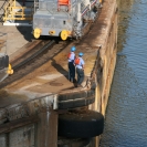 Lock workers standing above a big rolling bumper