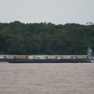 A barge with truck trailers headed upstream